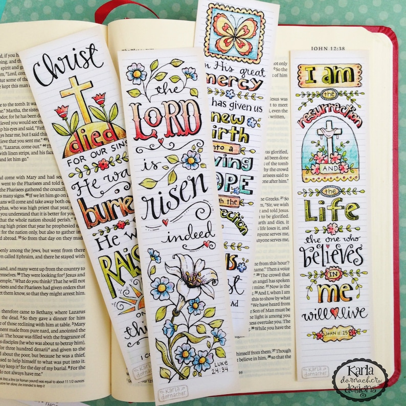 May include: Four colorful bookmarks with hand-drawn illustrations and inspirational Bible verses. The bookmarks feature a cross, flowers, butterflies, and the words "Christ died for our sins", "The Lord is risen indeed", "In His great mercy has given us new birth to a living hope", and "I am the resurrection and the life, the one who believes in me will live".