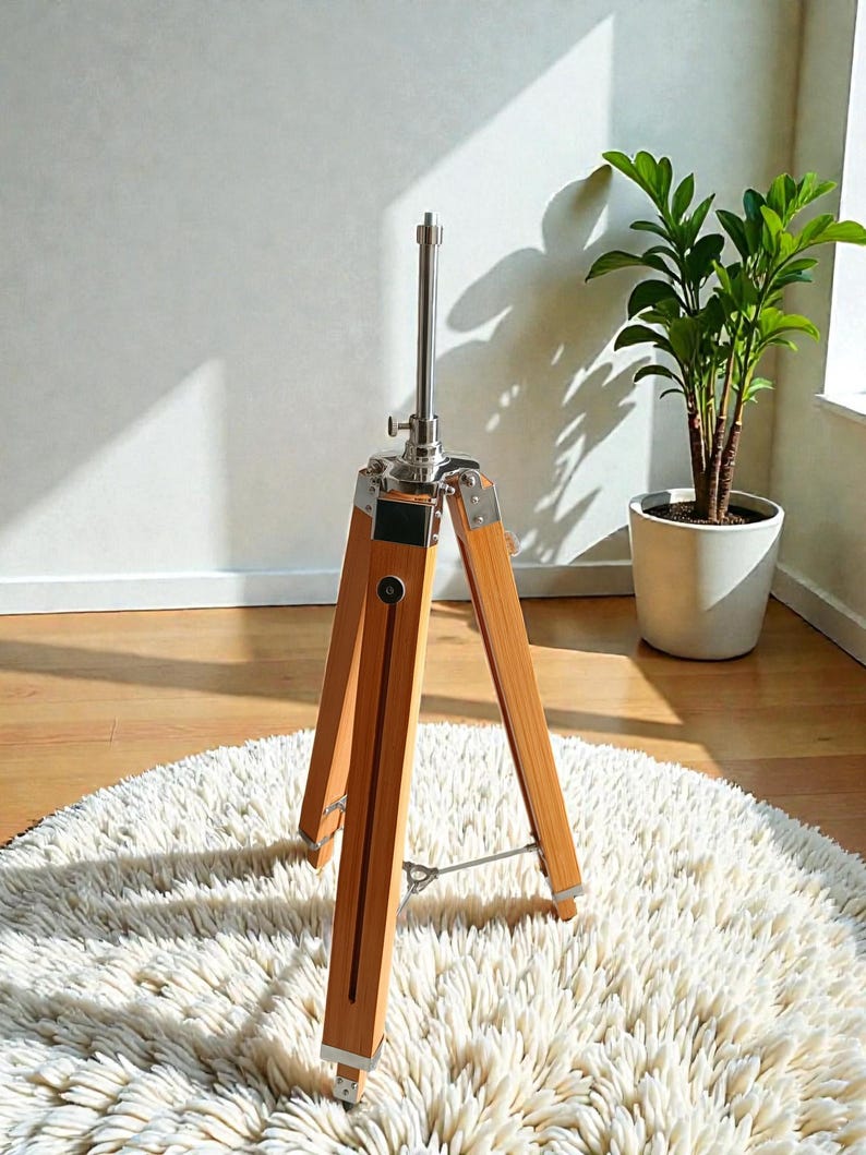 Vintage-style adjustable tripod stand handcrafted from premium teak wood with polished aluminium and nickel hardware. Features three sturdy wooden legs, an adjustable center column, and a height range of 25 to 50 inches. Ideal for DIY photo booths, DSLR cameras, floor lamps, studio décor, and nautical-inspired interiors. Handcrafted wooden tripod with a timeless industrial design.