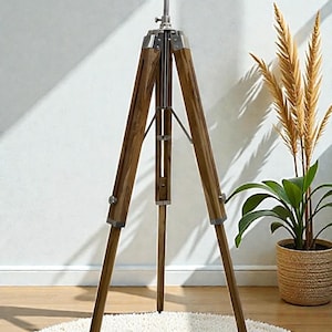 Vintage-style adjustable tripod stand handcrafted from premium teak wood with polished aluminium and nickel hardware. Features three sturdy wooden legs, an adjustable center column, and a height range of 25 to 50 inches. Ideal for DIY photo booths, DSLR cameras, floor lamps, studio décor, and nautical-inspired interiors. Handcrafted wooden tripod with a timeless industrial design.