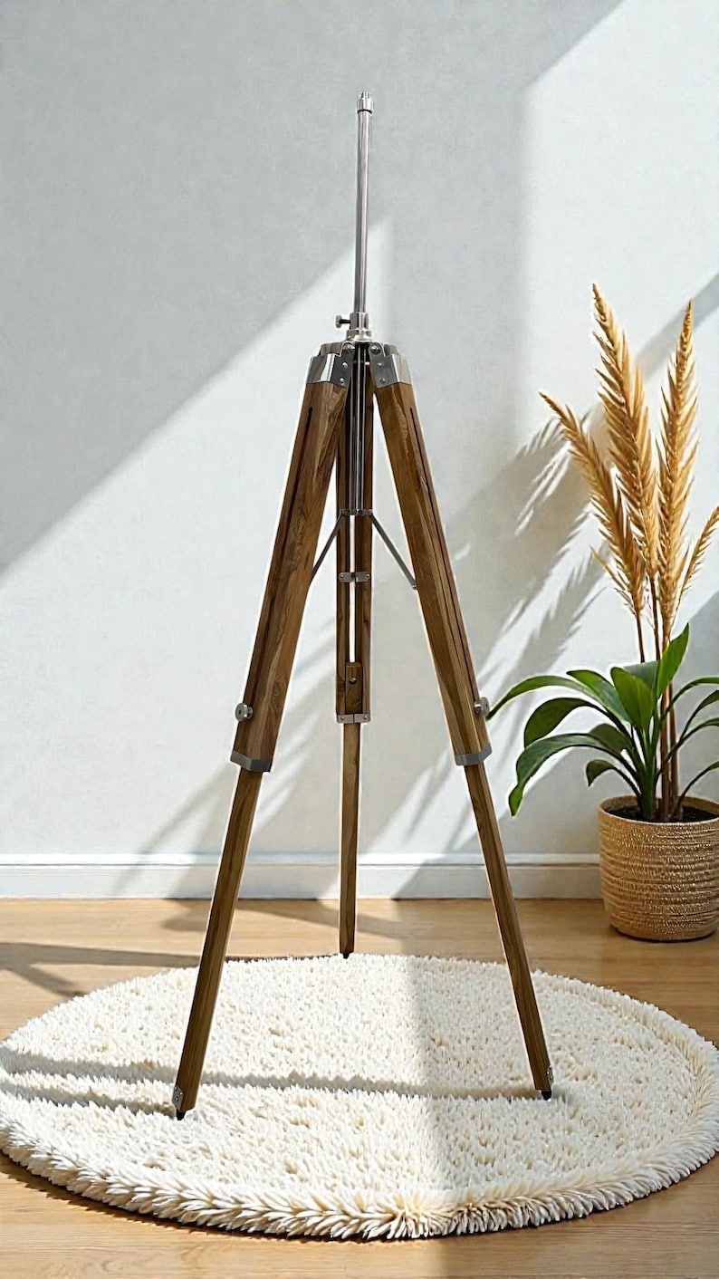 Vintage-style adjustable tripod stand handcrafted from premium teak wood with polished aluminium and nickel hardware. Features three sturdy wooden legs, an adjustable center column, and a height range of 25 to 50 inches. Ideal for DIY photo booths, DSLR cameras, floor lamps, studio décor, and nautical-inspired interiors. Handcrafted wooden tripod with a timeless industrial design.