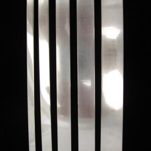 May include: Five silver metal strips of varying widths labeled 1/4, 3/8, 1/2, 5/8, and 3/4.