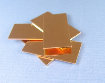 May include: A stack of five rectangular copper sheets, each with a shiny, metallic finish. The sheets are arranged in a slightly overlapping pattern, creating a visually interesting composition.