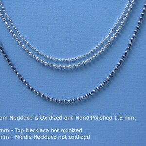 May include: Three silver ball chain necklaces on a blue background. The bottom necklace is oxidized and hand polished, measuring 1.5 mm. The middle necklace is not oxidized and measures 1.5 mm. The top necklace is not oxidized and measures 1.0 mm.