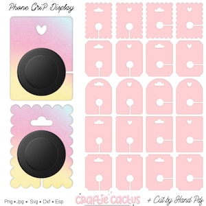 May include: A display of phone grip packaging and phone grips. The phone grip packaging is pink with a heart-shaped hole at the top and a circular hole at the bottom. The phone grips are black and round. The text "Phone Grip Display" is at the top.