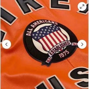 May include: Orange leather jacket with a black and white patch that says "All Americans NY Established 1975" and a black and white "US" patch.
