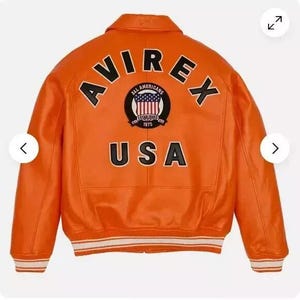 May include: Orange leather bomber jacket with a black and white "AVIREX" logo and a patch with the text "ALL AMERICANS ESTABLISHED 1975 USA".