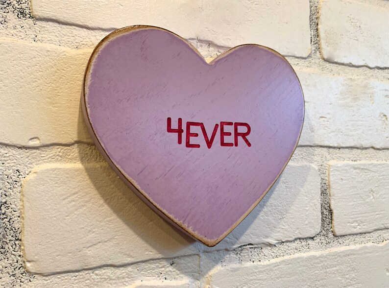 May include: A purple wooden heart-shaped sign with the word "4EVER" written in red.