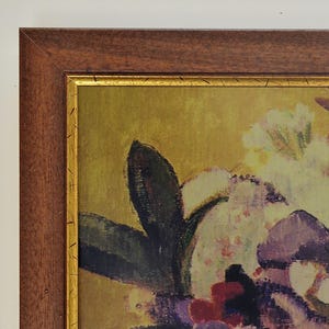 May include: An abstract floral painting in a wooden frame. The artwork features a bouquet of flowers in shades of purple, red, and white against a yellow background. The frame is a dark brown colour with a gold inner border.