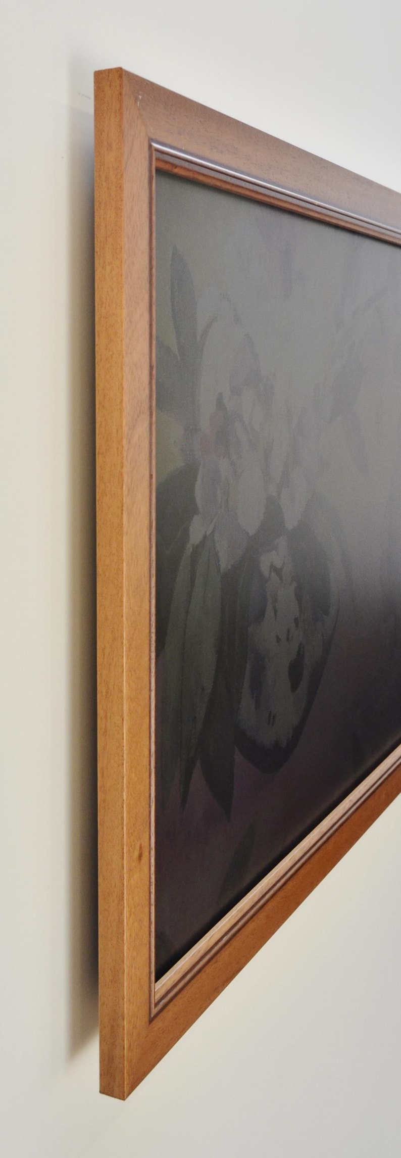 Peut inclure: Une &oelig;uvre d'art encadr&eacute;e repr&eacute;sentant une nature morte florale aux tons sourds. Le cadre en bois est de couleur marron clair et chaleureux. L'&oelig;uvre est accroch&eacute;e au mur.