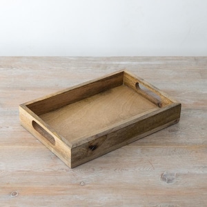 May include: A rectangular wooden serving tray with a natural light brown finish and visible wood grain. The tray features a flat base, four raised sides, and two integrated cutout handles on the shorter ends for easy carrying and handling.