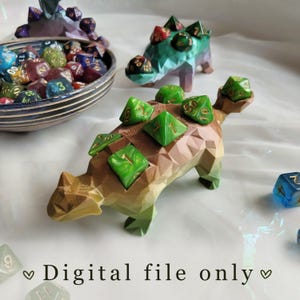 May include: A selection of polyhedral dice and dinosaur-shaped dice holders. The dice are in various colours, including green, blue, red, and purple. The dinosaur holders are in shades of brown, green, and blue. Text on the image reads "Digital file only."