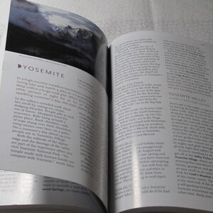 May include: An open book with a page featuring the word "YOSEMITE" and text describing Yosemite Valley. The page also includes a landscape photo of mountains. The book is open on a white surface.