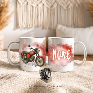 Könnte beinhalten: Weiße Keramik-Tasse mit einem roten Motorrad-Design, dem Wort "Simson" und einem rot-grauen Aquarellhintergrund. Die andere Seite der Tasse hat das Wort "Name" in Weiß. Die Tasse hat einen weißen Griff und steht auf einer beigen Oberfläche.