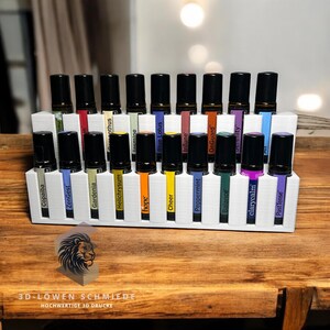 Könnte beinhalten: Weißer Plastik-Organizer mit 20 Fächern für ätherische Ölflaschen. Die Flaschen sind mit Namen wie "ZenGest", "Hope", "Peppermint" und "Past Tense" beschriftet.