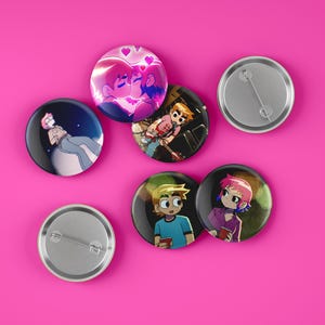 Op de afbeelding: Zes ronde pins met verschillende cartoonfiguren erop. De pins zijn zilverkleurig met een glanzende afwerking. De figuren zijn allemaal in verschillende poses en uitdrukkingen.