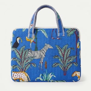 Pode incluir: Uma capa retangular acolchoada para portátil em azul brilhante com uma estampa de selva com uma zebra, um tucano e um leopardo. A bolsa inclui duas alças superiores com um padrão de riscas azuis e brancas e um fecho de correr branco.