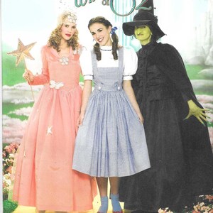 May include: Simplicity sewing pattern featuring costumes from The Wizard of Oz. Includes a pink gown, a blue gingham dress, and a black witch costume. The pattern size is R5, 14-22.