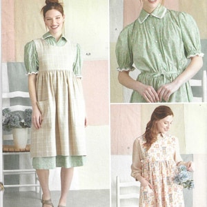 May include: Simplicity sewing pattern number S9835 for a dress with a pinafore style. The pattern includes three different styles: a green dress with a white collar, a plaid pinafore dress with a green blouse, and a floral pinafore dress with a pink blouse. The pattern is easy to sew and includes instructions for sizes XS-XL.