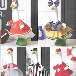 May include: A Simplicity S3298 sewing pattern envelope featuring five white goose figurines dressed in various outfits: a football player with a helmet, a cheerleader with pom-poms, a baseball player, a referee with a whistle, and a lifeguard.
