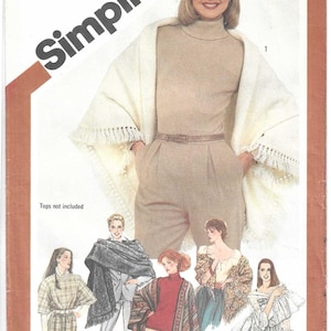 May include: A Simplicity sewing pattern envelope 5210 for a one-size shawl. The cover features a photograph of a person wearing a cream-colored fringed shawl over a beige turtleneck and trousers, with illustrations of five additional shawl variations.