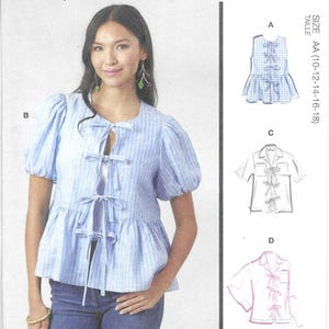 May include: McCall's sewing pattern M8557 featuring multiple blouse designs. The image shows a woman wearing a blue and white striped blouse with bow details. The pattern includes different views and sizes AA (10-12-14-16-18).