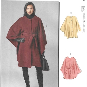 May include: McCall's sewing pattern M8628 features a maroon cape with a tie waist, black gloves, and black boots. Illustrations show two additional cape variations in yellow and pink, with sizes ranging from XS to XXL listed on the side.