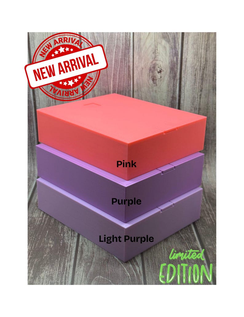 May include: A stack of three rectangular boxes in shades of pink, purple, and light purple. The top box is pink, the middle box is purple, and the bottom box is light purple. The boxes have the words "Pink", "Purple", and "Light Purple" printed on them.
