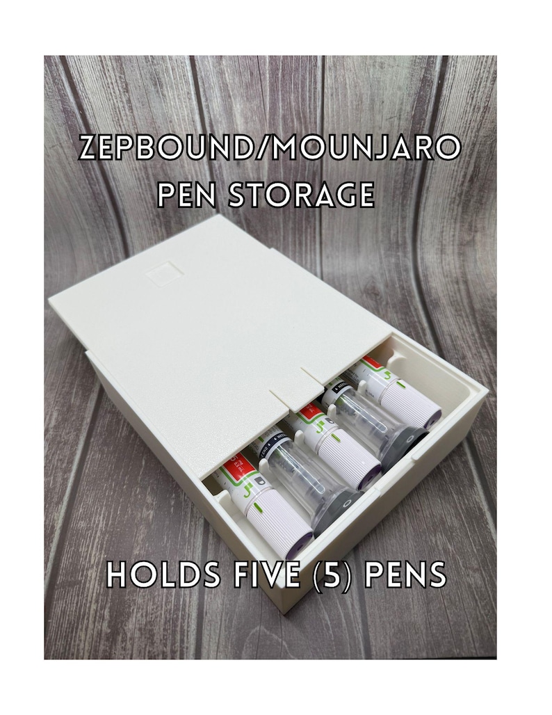 May include: A white pen storage box with a hinged lid, holding five pens. The box has the text "ZEPBOUND/MOUNJARO PEN STORAGE" and "HOLDS FIVE (5) PENS" printed on it. The pens are visible inside the box.