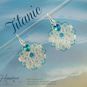 May include: Silver earrings with a delicate, intricate design featuring blue and white beads. The earrings are shaped like a teardrop and have a crystal in the centre. The word "Titanic" is written in cursive at the top of the image.