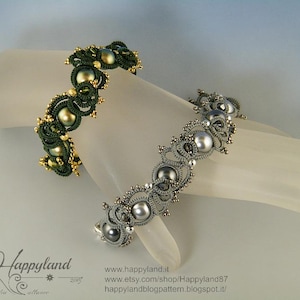 Pode incluir: Duas pulseiras de contas. Uma é verde escuro com detalhes dourados e contas redondas grandes. A outra é prateada com contas cinzentas. Ambas as pulseiras são exibidas em uma forma branca em forma de mão.