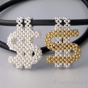 Può includere: Due ciondoli a forma di dollaro in argento e oro, realizzati con piccole perline. I ciondoli sono appesi a un cordoncino nero.