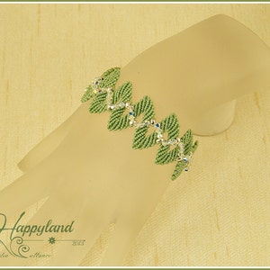 Peut inclure: Un bracelet en perles vertes avec des accents de cristal. Le bracelet est sur un bras de mannequin blanc.