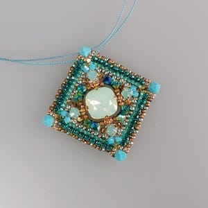 May include: A square pendant necklace with a turquoise and gold beaded design. The pendant features a large, iridescent, white gemstone in the center.