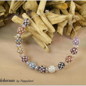 May include: A silver hoop necklace with a beaded chain of colourful, iridescent, and clear round beads. The beads are arranged in a rainbow pattern.