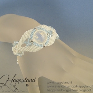 Peut inclure: Bracelet en macramé blanc et bleu clair avec une grande pierre précieuse ovale transparente au centre. Le bracelet est décoré de petites perles bleu clair.