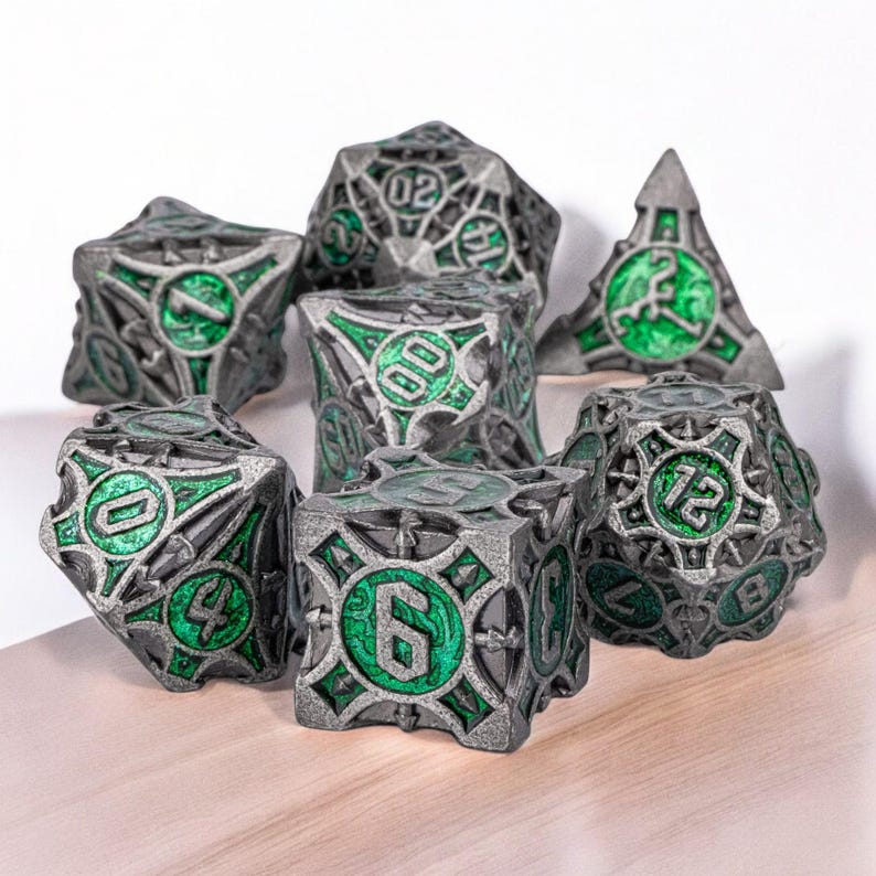 May include: A set of seven metal dice with a green and silver finish. The dice are shaped like cubes with intricate designs and numbers on each side.