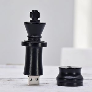 May include: Black chess piece shaped USB drive with a silver USB connector. The drive is shaped like a chess king piece.