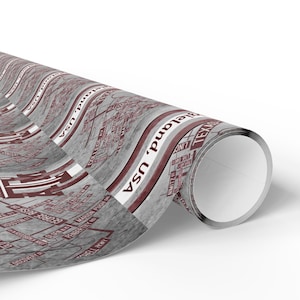 May include: Rolled gift wrap featuring a map design with street names and the text "Bieland, USA" in a repeating pattern. The wrap has a gray background with red and white accents, and the roll is partially unraveled.