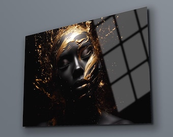 May include: A close-up of a person's face with gold paint splattered on their skin. The background is black with a window in the upper right corner.