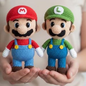 May include: Two handmade crochet dolls of Mario and Luigi. Mario wears a red hat with a white "M", a red shirt, blue overalls, and brown shoes. Luigi wears a green hat with a white "L", a green shirt, blue overalls, and brown shoes.