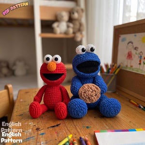 Könnte beinhalten: Zwei gehäkelte Plüschpuppen, eine rote mit einer großen orangefarbenen Nase und eine blaue mit schwarzem Mund, die einen beigen, strukturierten Keks hält. Beide Puppen haben große weiße Augen mit schwarzen Pupillen. Der Text PDF PATTERN und English Pattern ist sichtbar.