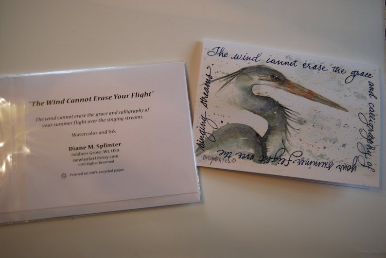 May include: Two watercolor greeting cards with a blue heron and the text "The wind cannot erase the grace and calligraphy of your summer flight over the singing streams." and "The Wind Cannot Erase Your Flight".