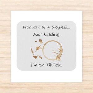 May include: A white card with a coffee stain and the text "Productivity in progress... Just kidding, I'm on TikTok."