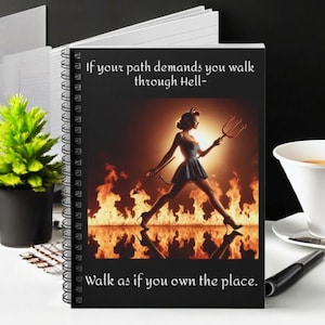 May include: A black and white spiral bound notebook with a motivational quote: "If your path demands you walk through Hell - Walk as if you own the place." The cover features a woman in a red devil costume walking through flames.
