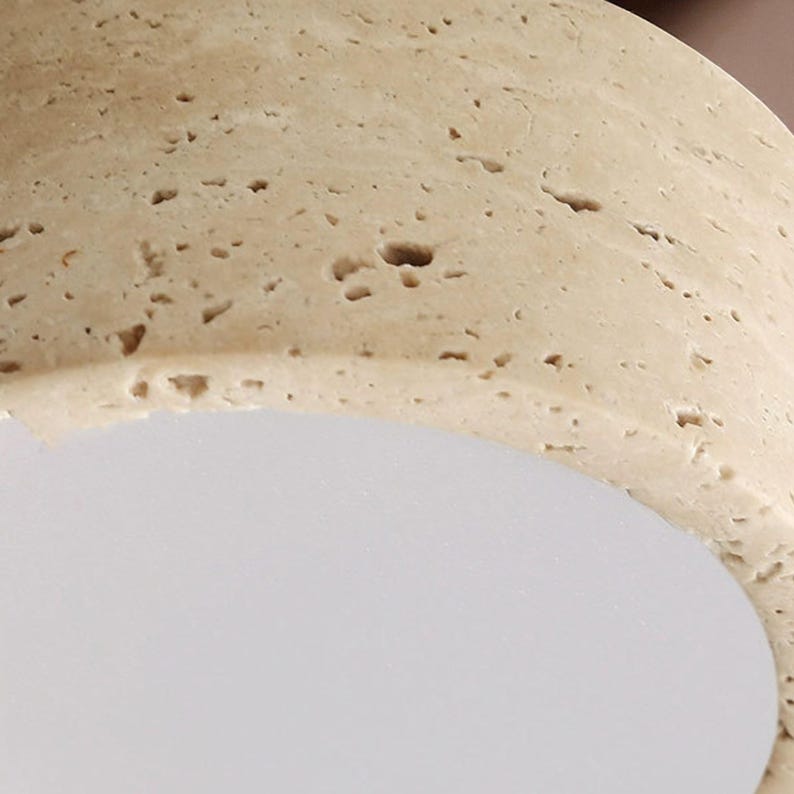 May include: Close-up of a light beige, textured, rounded object with small holes and a smooth, white, curved surface. The object has a natural, porous appearance.