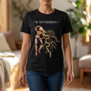 Puede incluir: Una camiseta negra de manga corta con un gráfico de un maniquí de madera de artista emitiendo rayos amarillos desde su cabeza. Sobre el maniquí, el texto "¡ YO SOY PODEROSO !" aparece en una fuente blanca de estilo manuscrito.