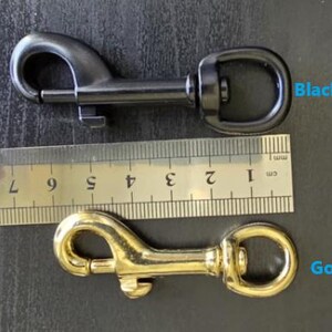 May include: A black snap clip and a gold snap clip positioned next to a metal ruler. The ruler shows the clips are approximately 3 inches in length. The text Black Snap Clip and Gold Snap Clip is visible next to the respective metal hardware items.