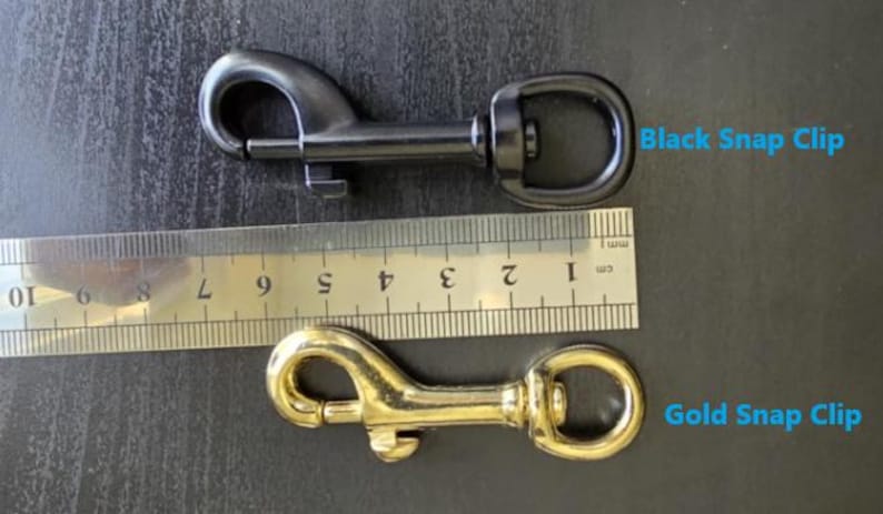 May include: A black snap clip and a gold snap clip positioned next to a metal ruler. The ruler shows the clips are approximately 3 inches in length. The text Black Snap Clip and Gold Snap Clip is visible next to the respective metal hardware items.