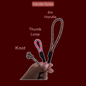 K&ouml;nnte beinhalten: Drei Seilgriffstile mit der Beschriftung Handle Styles: ein Knoten, eine Daumenschlaufe aus pink-t&uuml;rkis gemustertem Seil und ein 15,24 cm langer Griff aus schwarz-orange gemustertem Seil. Jeder Seilabschnitt ist mit einem schwarzen Verbinder fixiert.