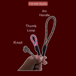 May include: Three rope handle styles labelled Handle Styles: a knot, a thumb loop with pink and teal patterned rope, and a 15.24cm handle with black and orange patterned rope. Each rope section is secured with a black connector at the base.